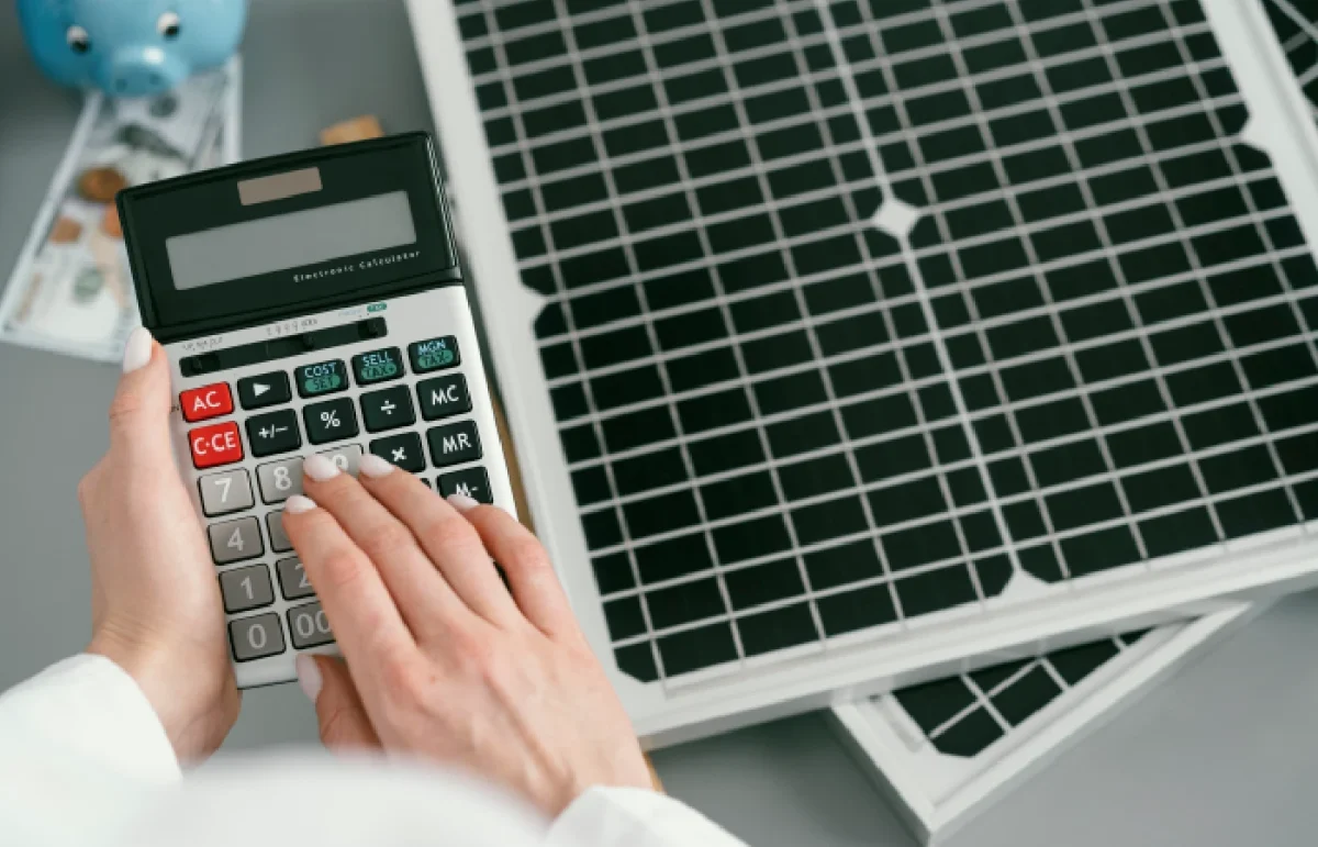 A calculator with a solar panel in the background