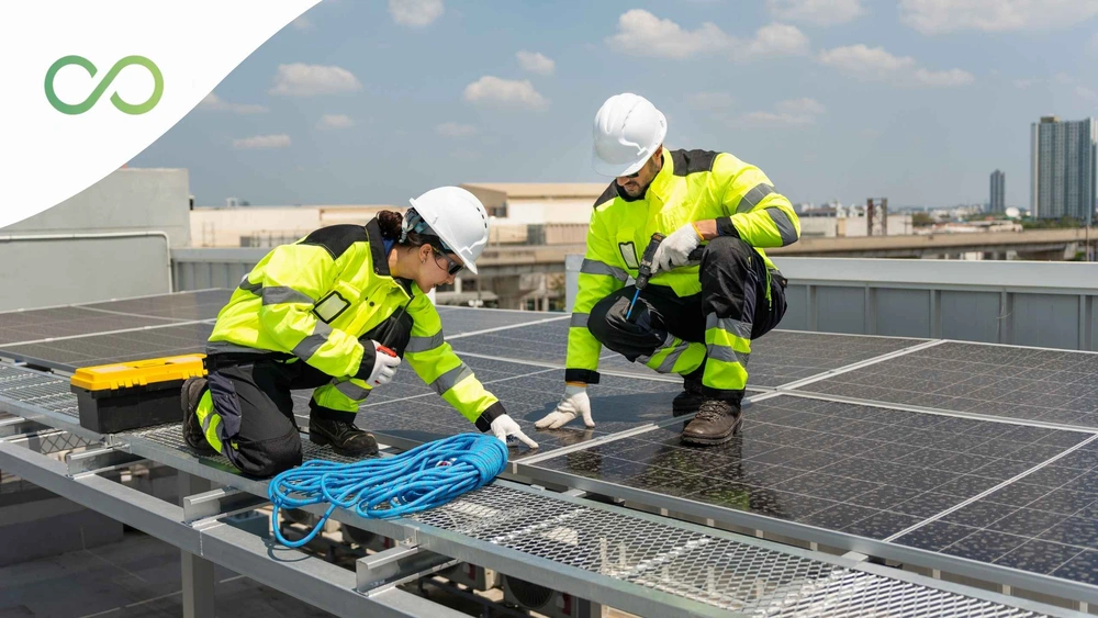 Dos personas sobre el techo de una edificación con páneles solares revisando Marco normativo: NSR-10 y Resolución 0194 de 2025 Construcciones sostenibles en Colombia Green Loop