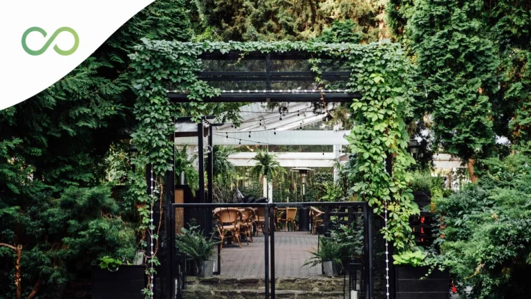 Corredor con muchas plantas alrededor y al fondo un comedor Restaurante sostenible: guía práctica 2026 green loop