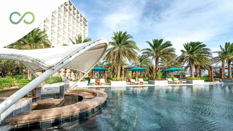 Luxury tropical resort pool with palm trees and modern sustainable architecture How Hotels Reach Net Zero: A 7-Step Roadmap for US and Caribbean Operators Green Loop