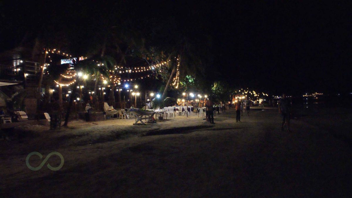 Beach club at night with palm trees, outdoor seating, and string lights along the shore These are some case examples from the region green loop