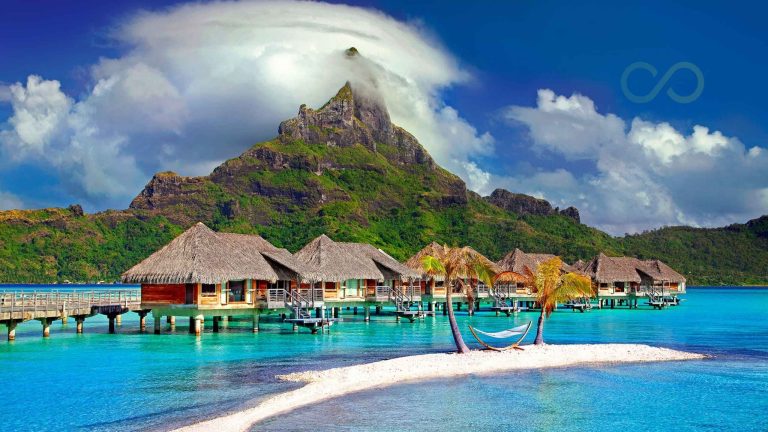 Caribbean resort with overwater bungalows, turquoise waters, and a mountain backdrop Case Study: A Caribbean Resort's EarthCheck Certification Journey green loop