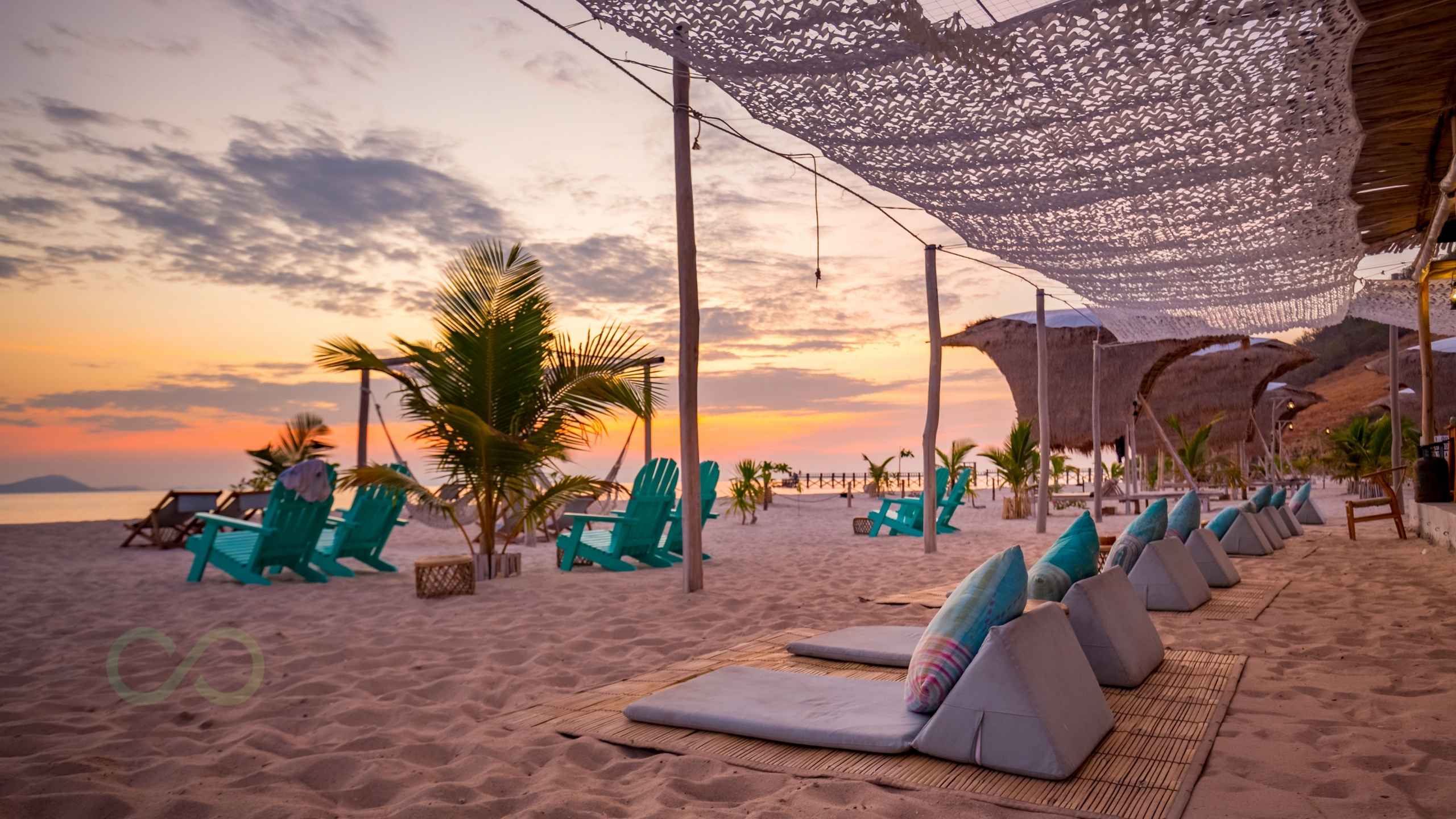 Sustainable beach club with palm trees, lounge chairs, and shaded seating at sunset EarthCheck Certification for Sustainable Beach Clubs green loop