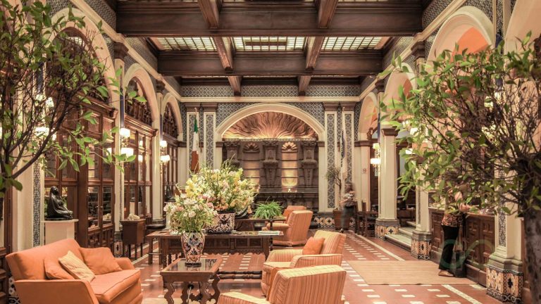 Historic hotel lobby with ornate architecture, indoor greenery, and traditional Moroccan-inspired design Regenerative Hospitality for US and Caribbean Hotels in Green Loop 2026
